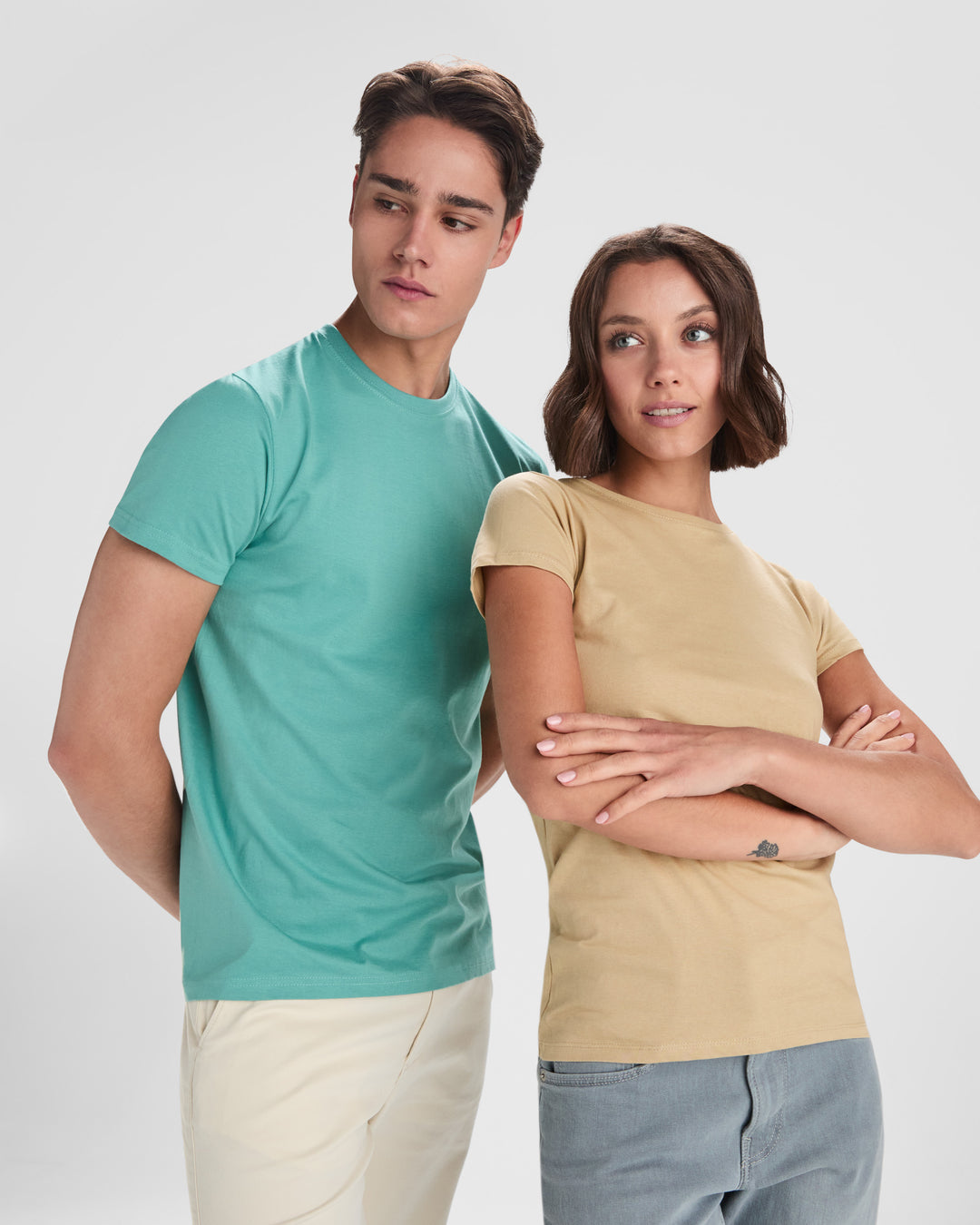 Two people wearing plain t-shirts against a white background